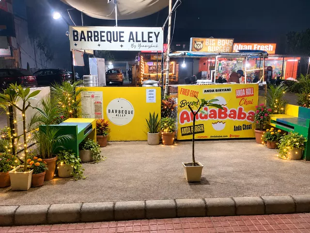 Barbeque Alley night outlet framed by plants, flowers and subtle warm lights