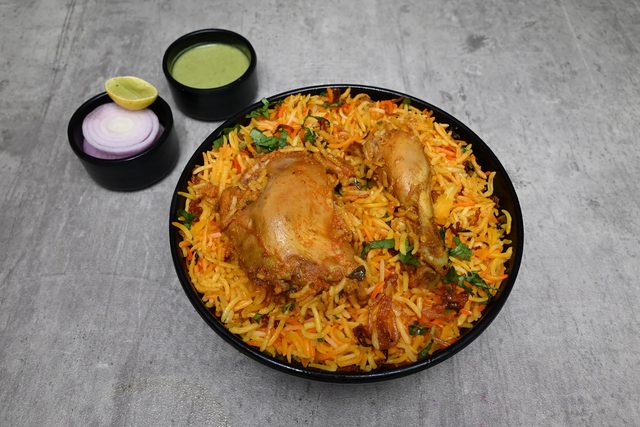 Chicken biryani with lemon, onion and chutney